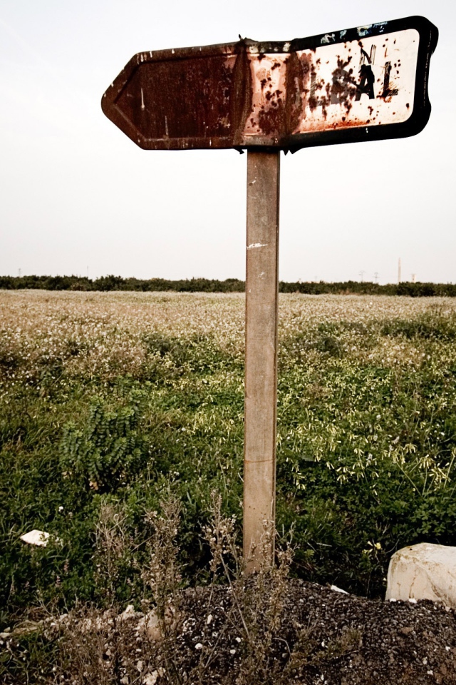Ржавый указатель направления у поля
