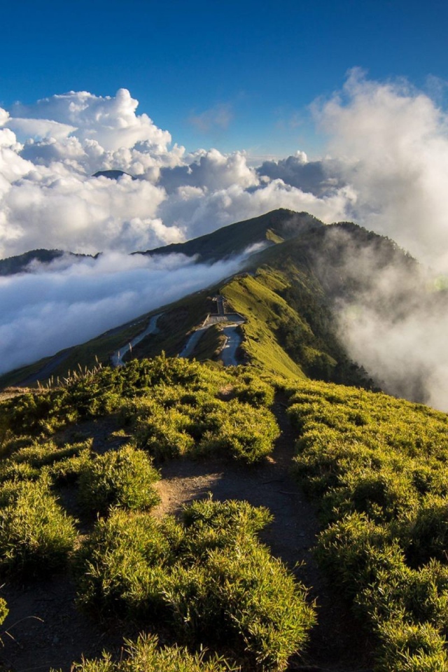 Зеленый горный хребет среди облаков
