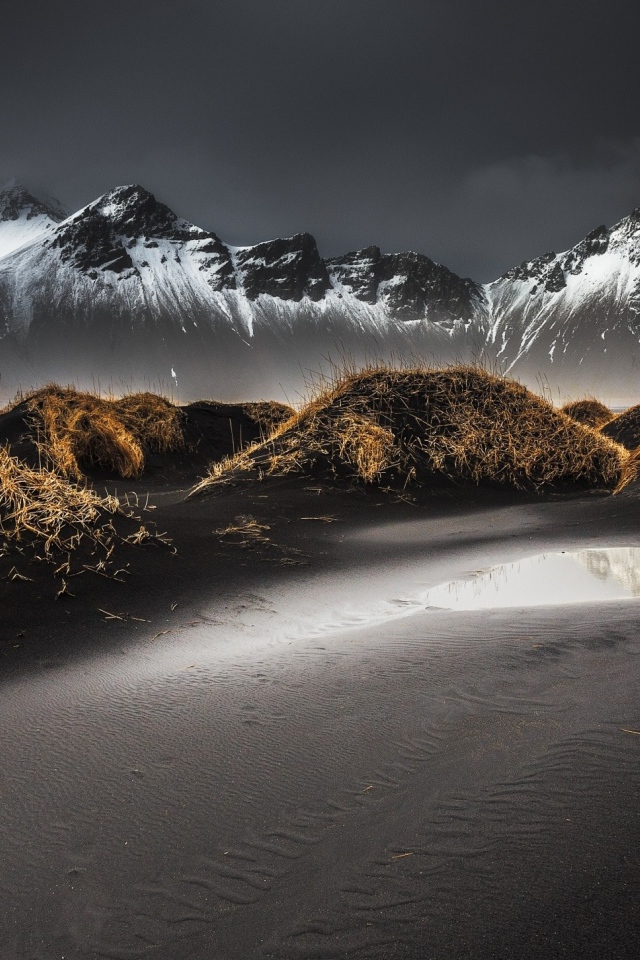 Серый песок на фоне гор