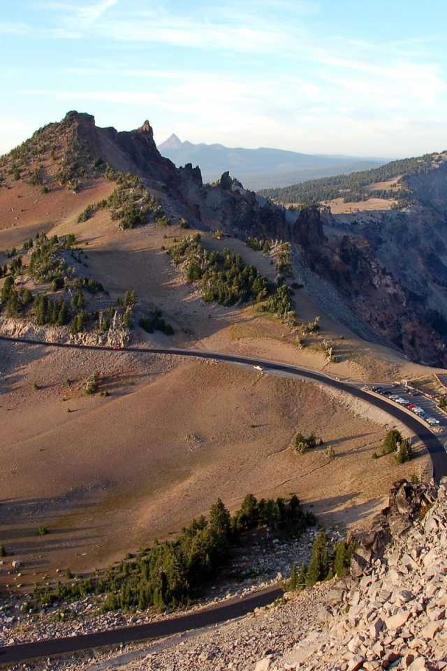 Шоссе огибает скалы у озера в горах