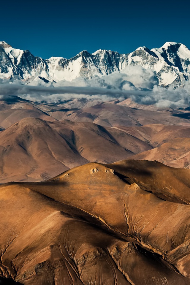 Покрытые снегом вершины высоких гор над плоскогорьем