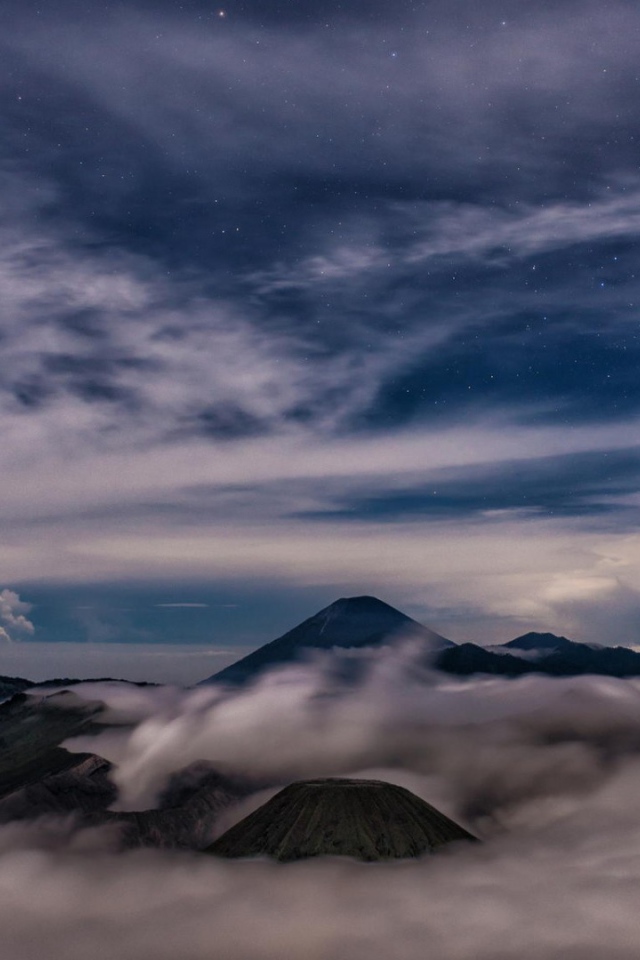 Звездное небо над облаками и туманом в горах