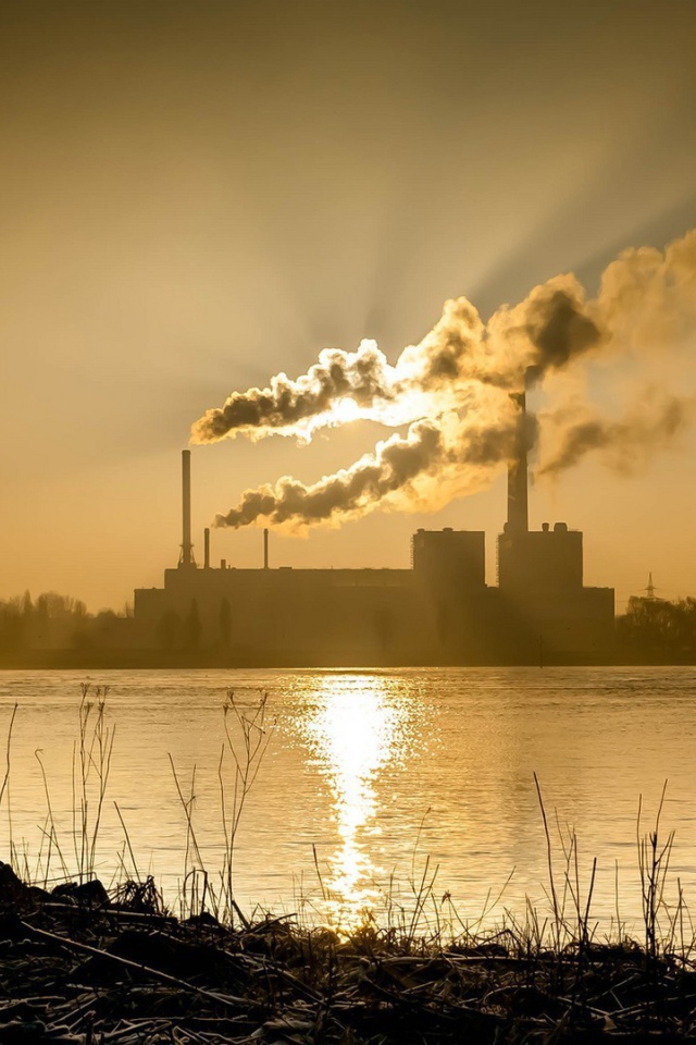 Лучи солнца пронизывают дым из заводских труб