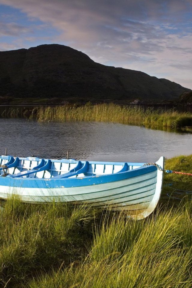 Синяя лодка на берегу озера