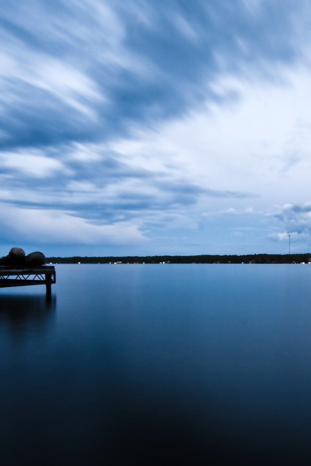Силуэт человека на пристани у озера