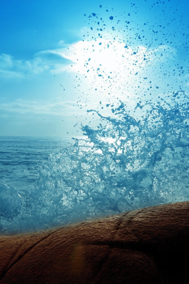 Голубая волна разбилась о камень на берегу