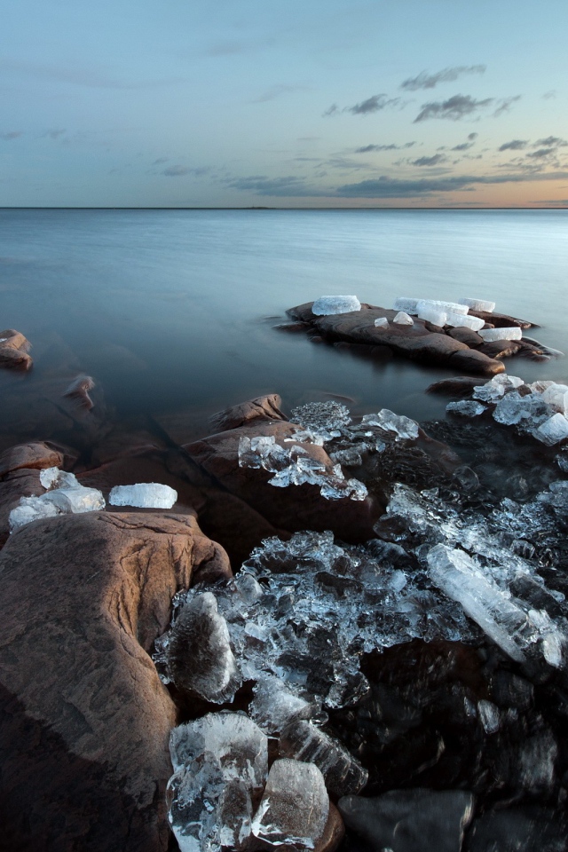 Куски льда на камнях у берега