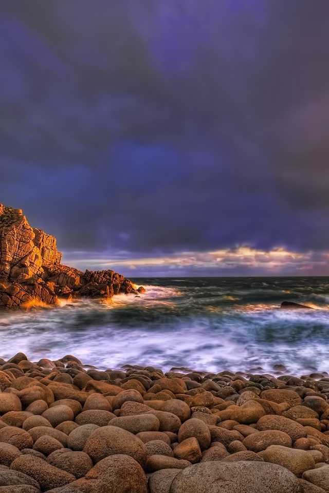 Большие гладкие камни на берегу бурного моря