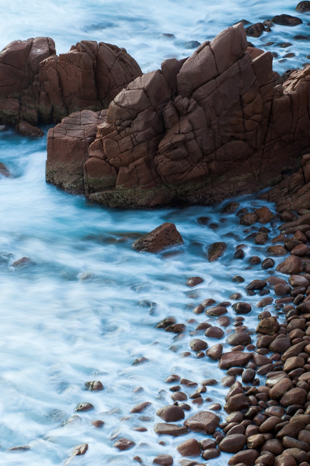 Мелкие коричневые камни на берегу моря