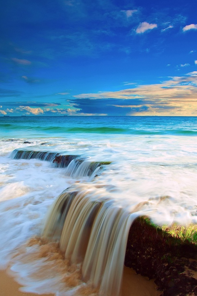 Волна прибоя накатывает на прибрежные камни