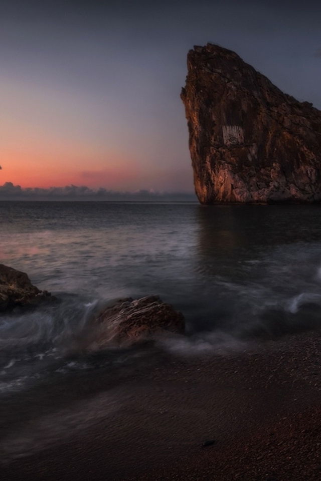 Треугольная скала на берегу моря