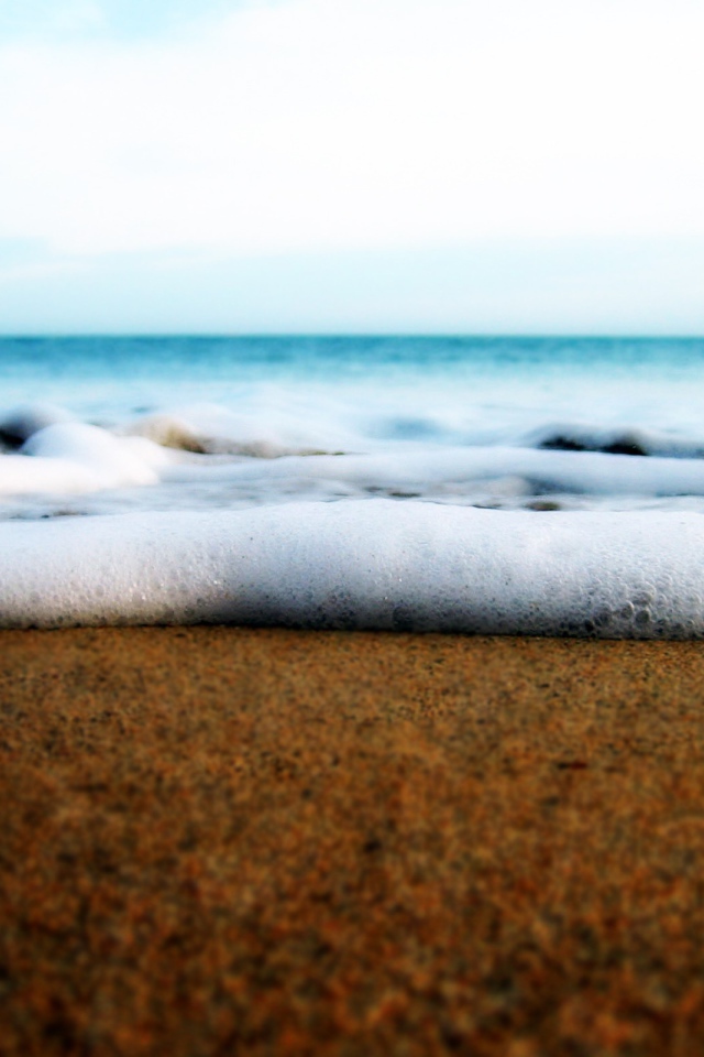 Белая пена волны у берега