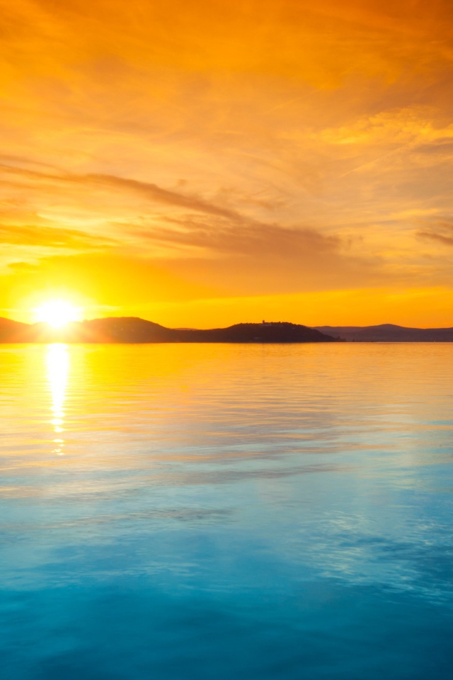 Оранжевое небо над голубой водой на закате