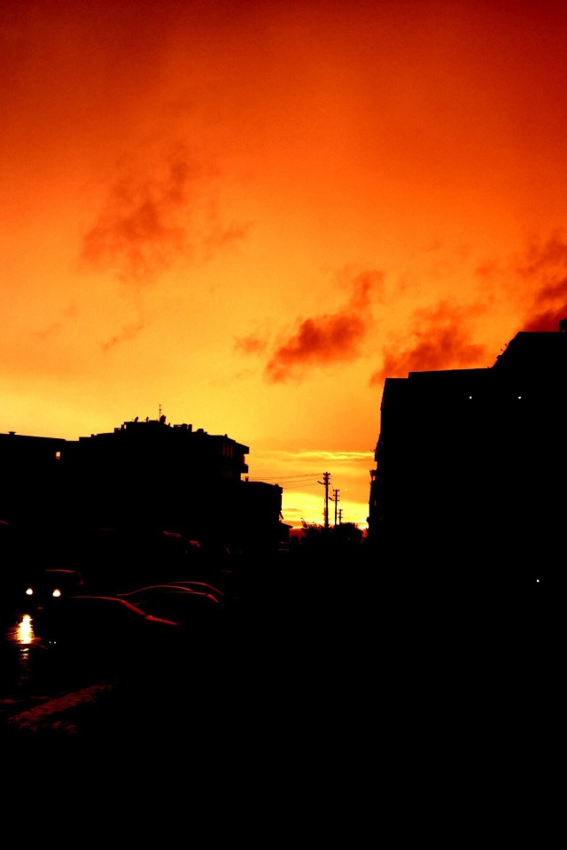 Силуэты зданий на фоне оранжевого неба