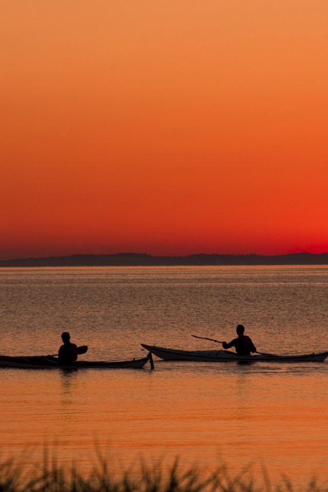 Два лодочника на фоне заката