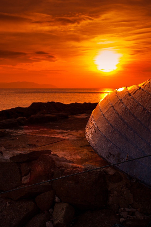 Перевернутая лодка на фоне заката