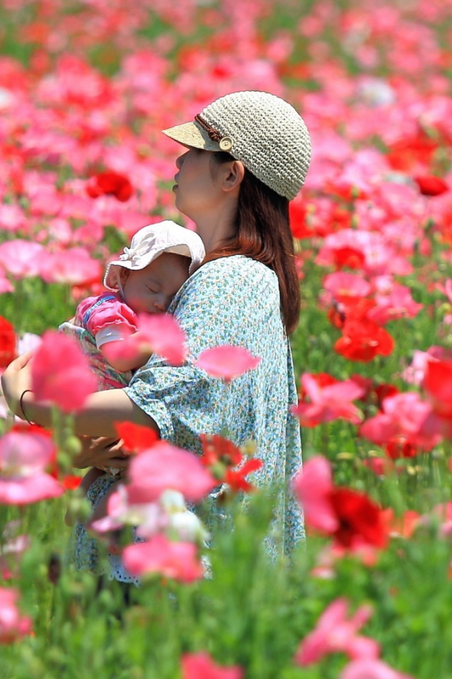 Девушка с ребенком идет по полю цветов