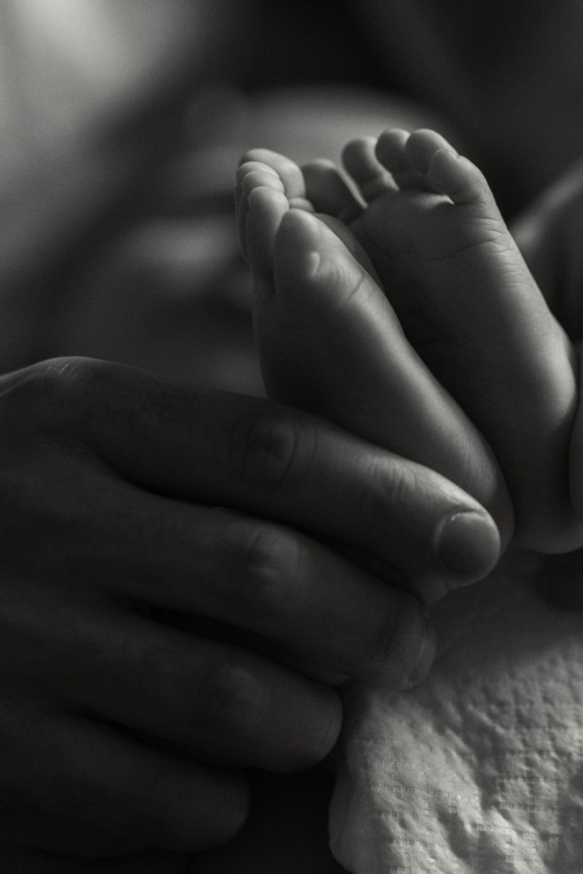Ступни ребенка в руках отца