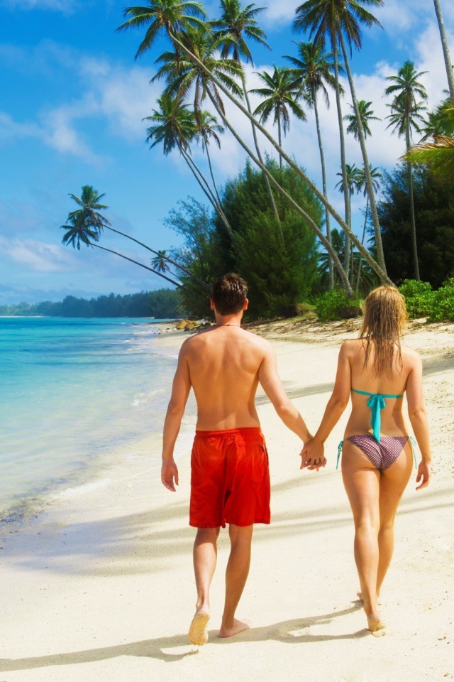 Парень и девушка идут по пляжу