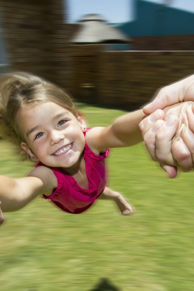 Веселая девочка в руках отца