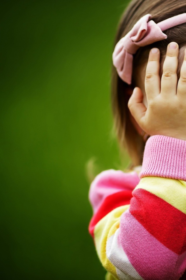 Милая девочка закрыла лицо руками
