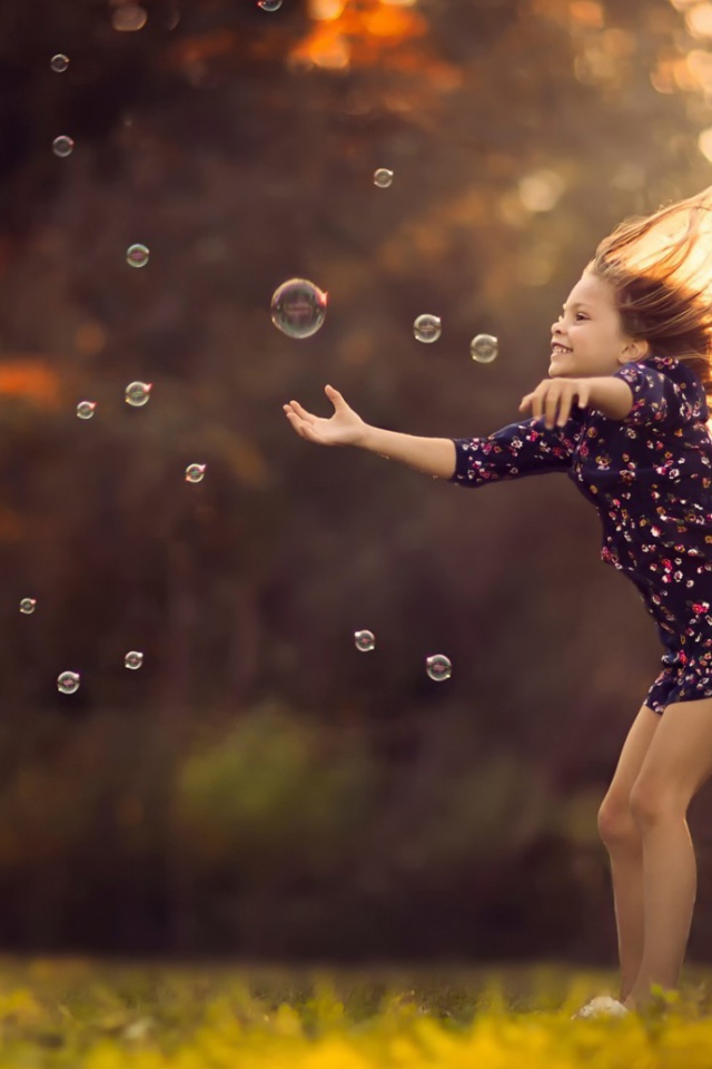 Девочка играет с мыльными пузырями