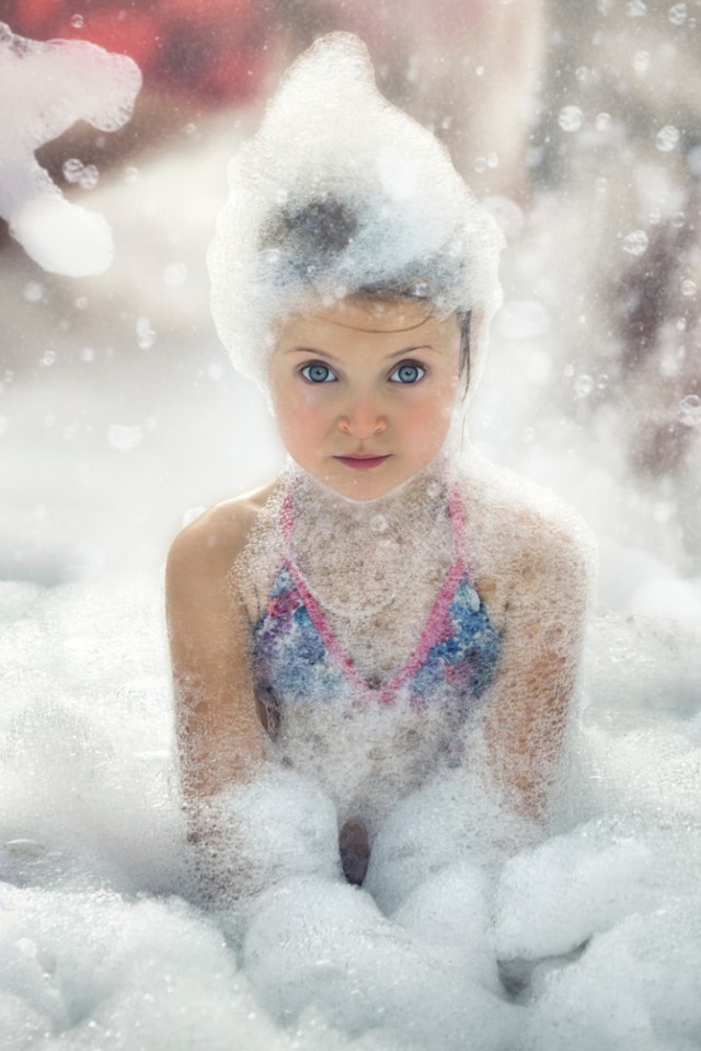 Девочка играет в пене