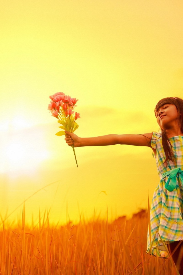 Девочка с букетом стоит в поле