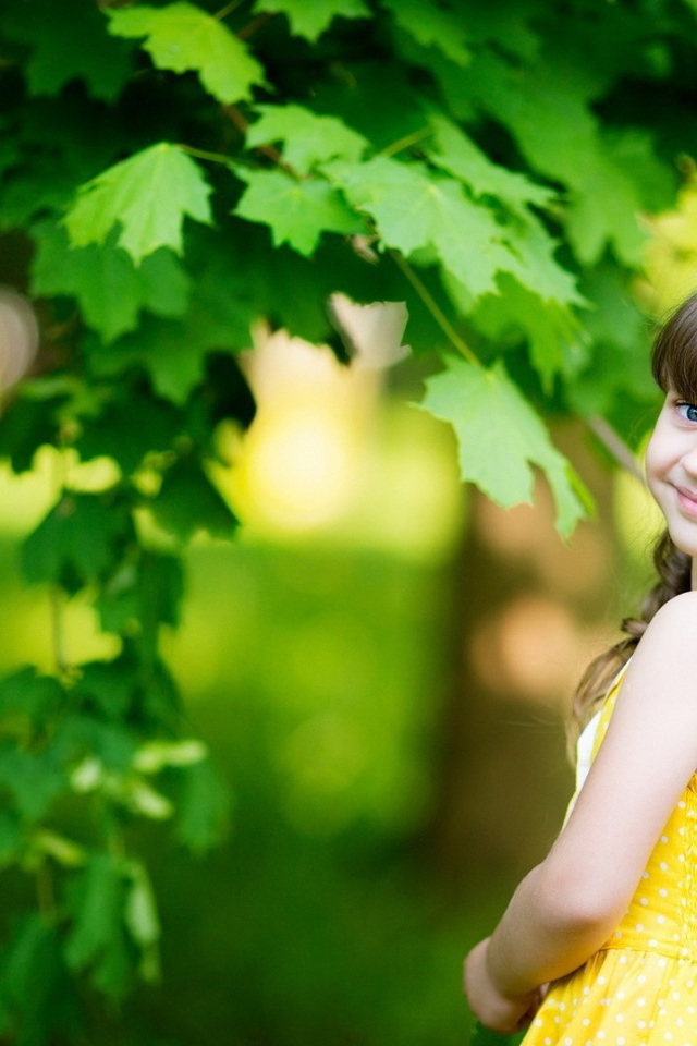 Маленькая девочка у зеленого клена