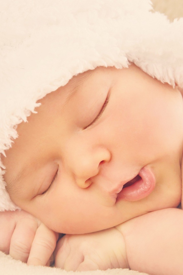 Спящий ребенок в белой шапке