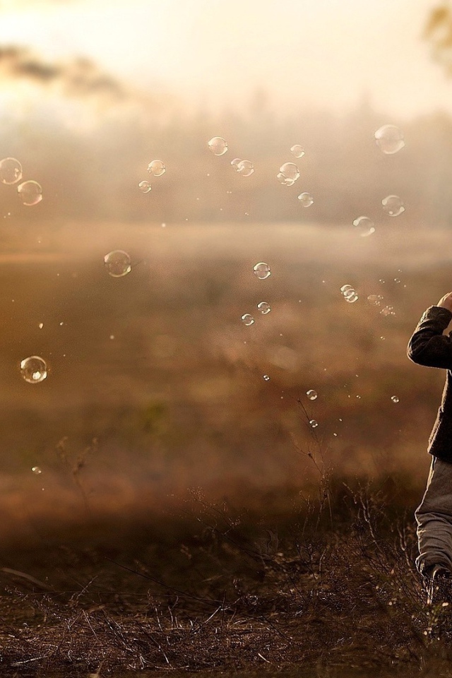 Мальчик запускает мыльные пузыри