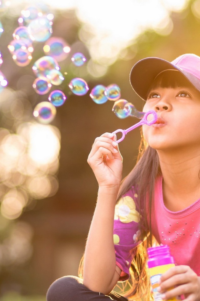 Девочка запускает мыльные пузыри