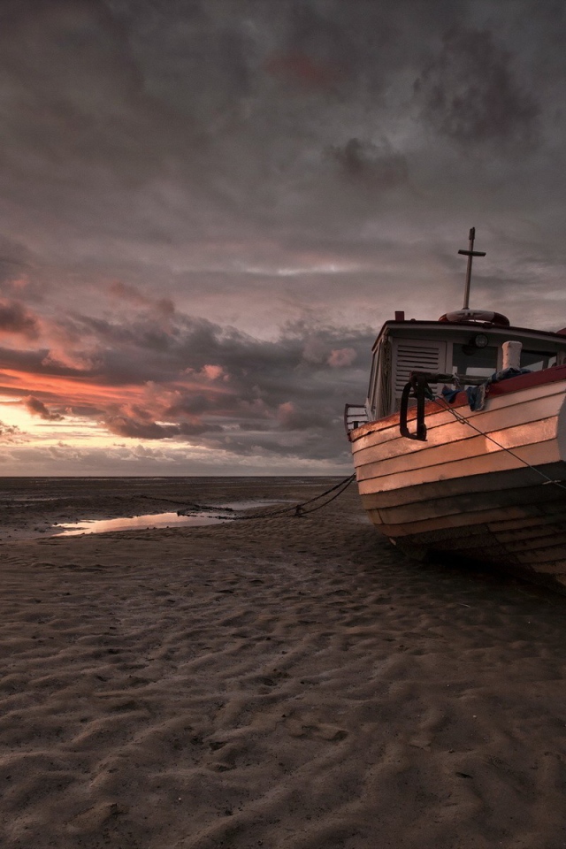 Лодка на песке пляжа во время отлива
