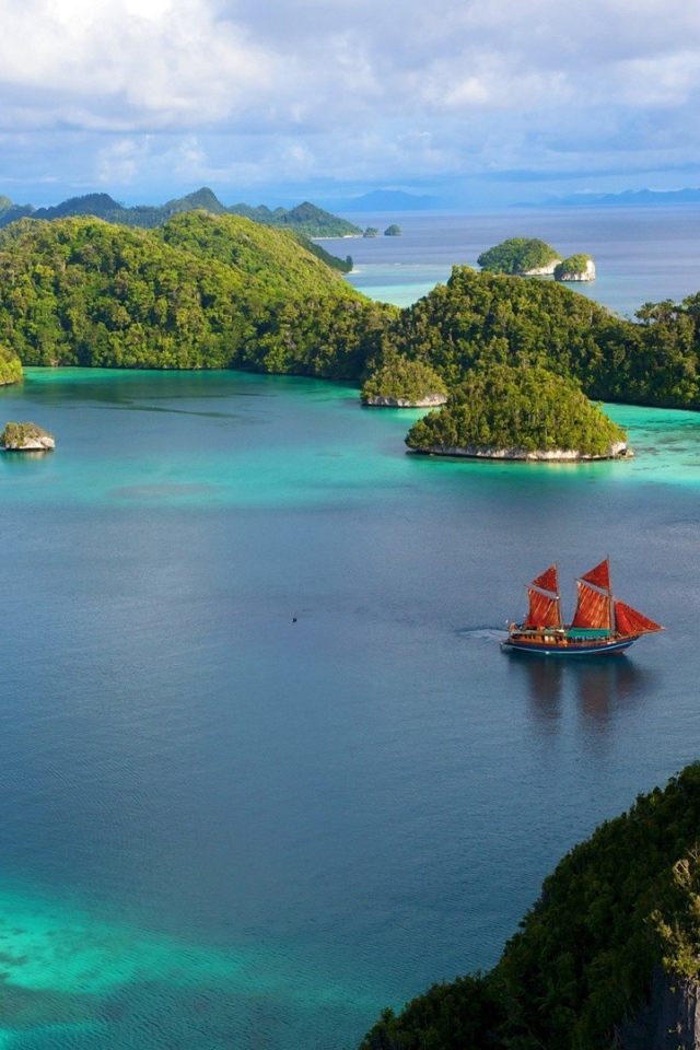 Корабль с красными парусами среди островов