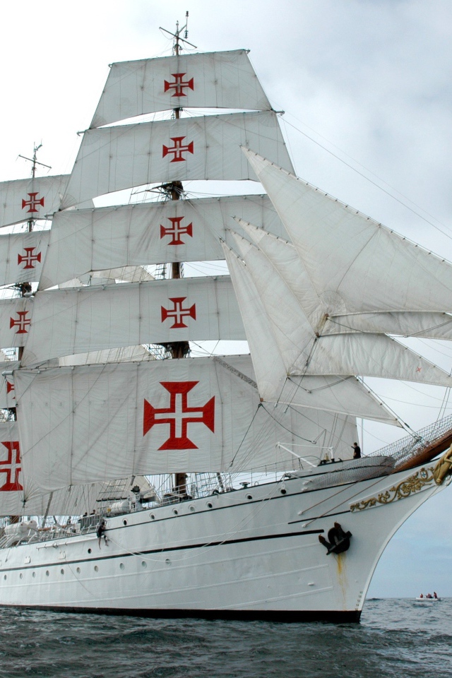 Кресты на парусах белого корабля