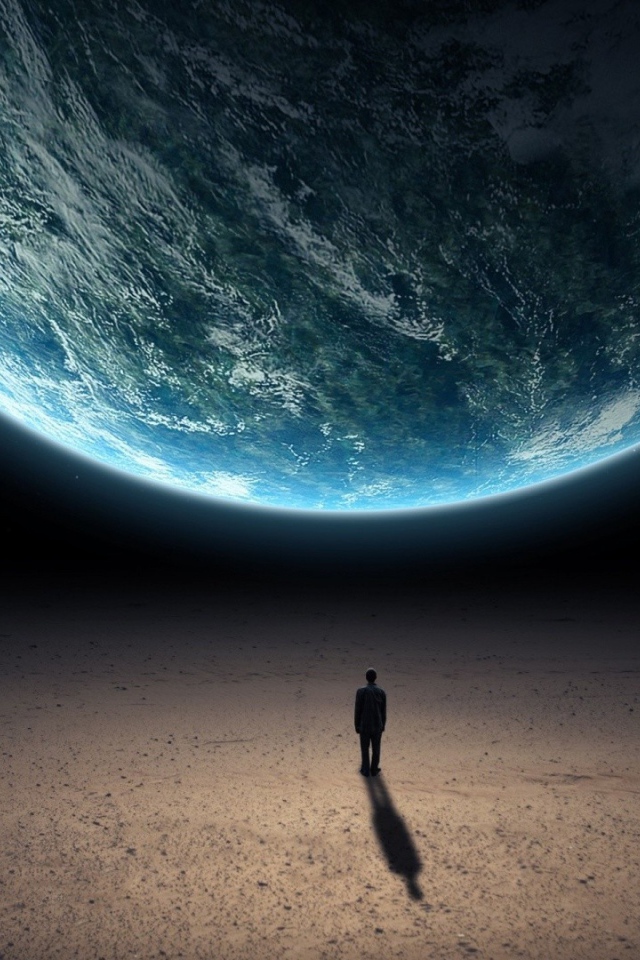 Человек стоит перед планетой