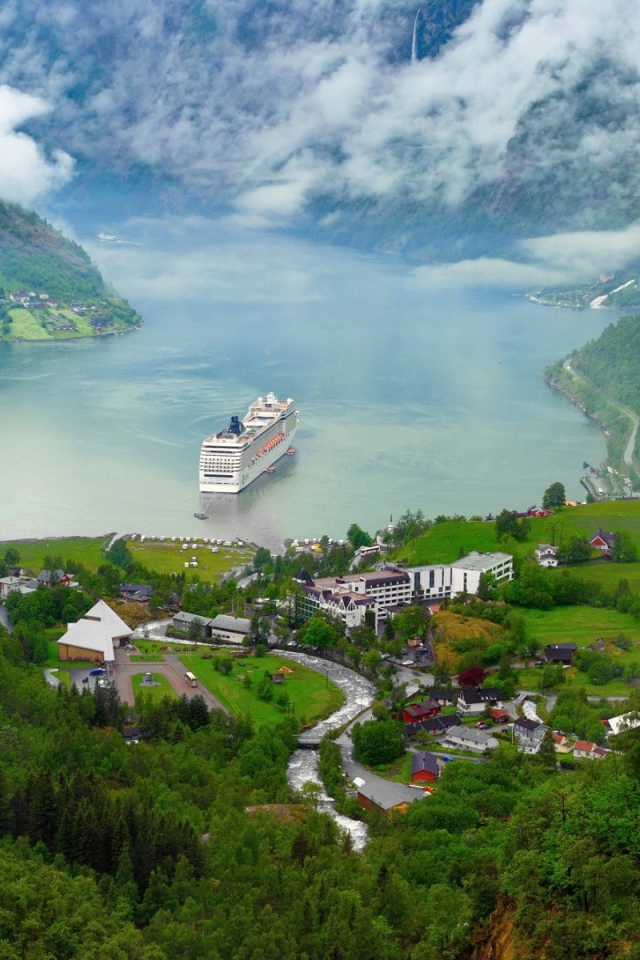 Круизный корабль у прибрежной деревушки в Норвегии