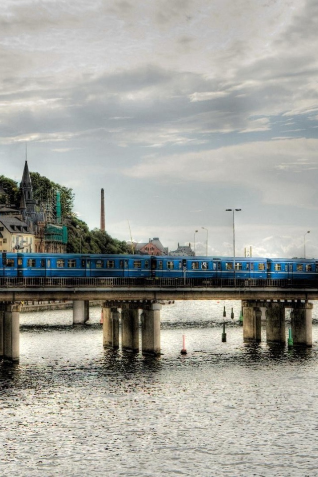 The train crosses the bridge over the river in Sweden