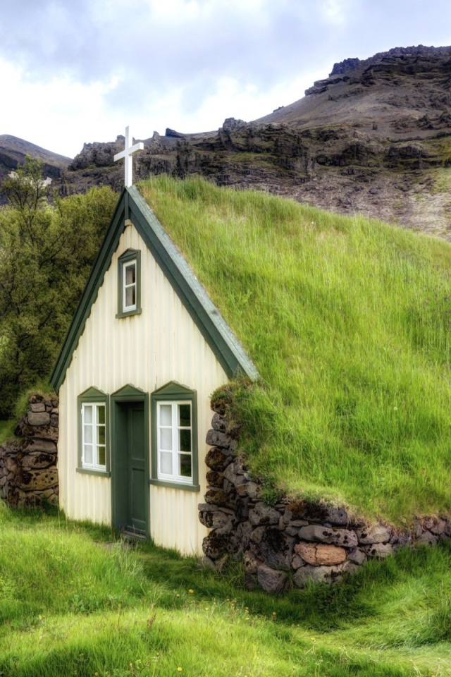 Поросшая травой крыша церкви в горной деревушке