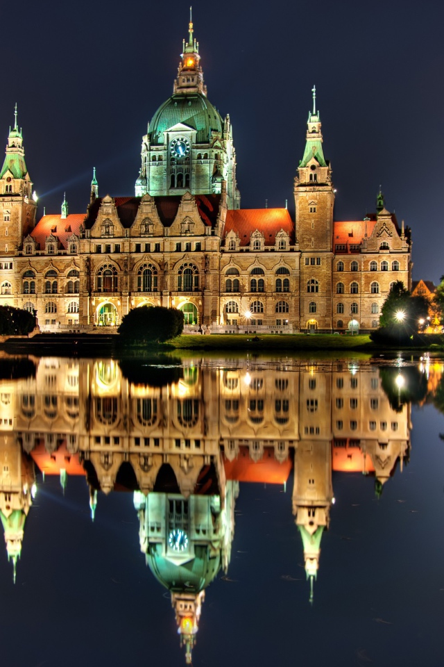 Освещенный замок с часами на башне