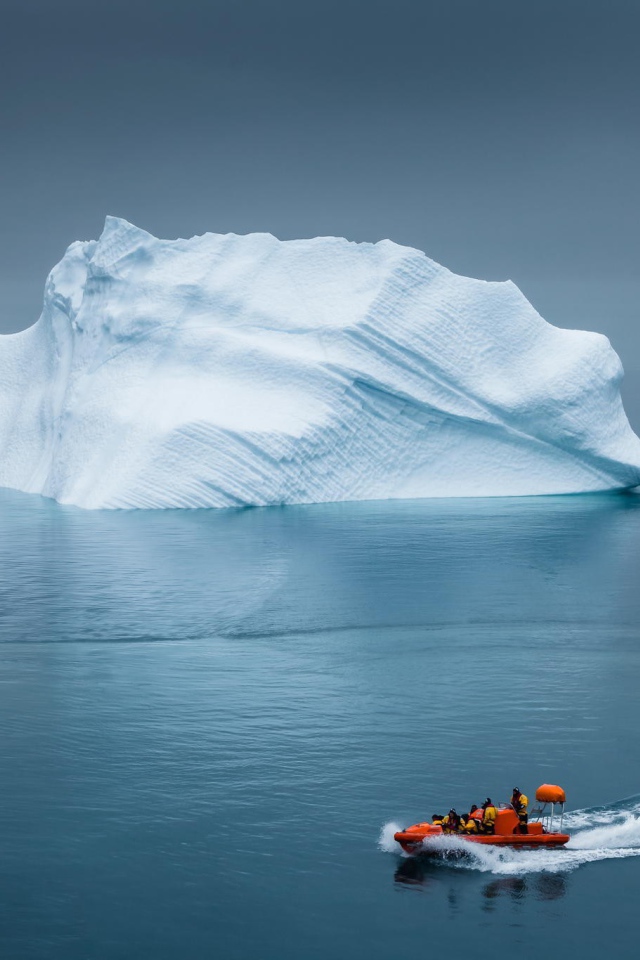 Моторная лодка у айсберга в Арктике