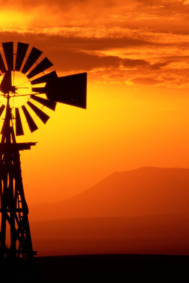 Ветряк флюгер на фоне заката, США