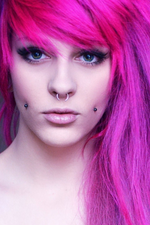Девушка с розовыми волосами и пирсингом в щеках