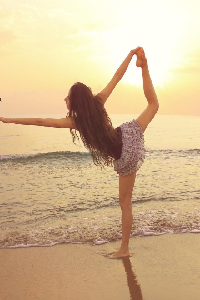 Балерина на берегу моря с птицей