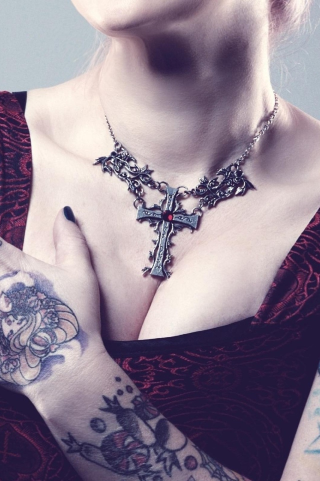 Красивый кулон на груди татуированной девушки