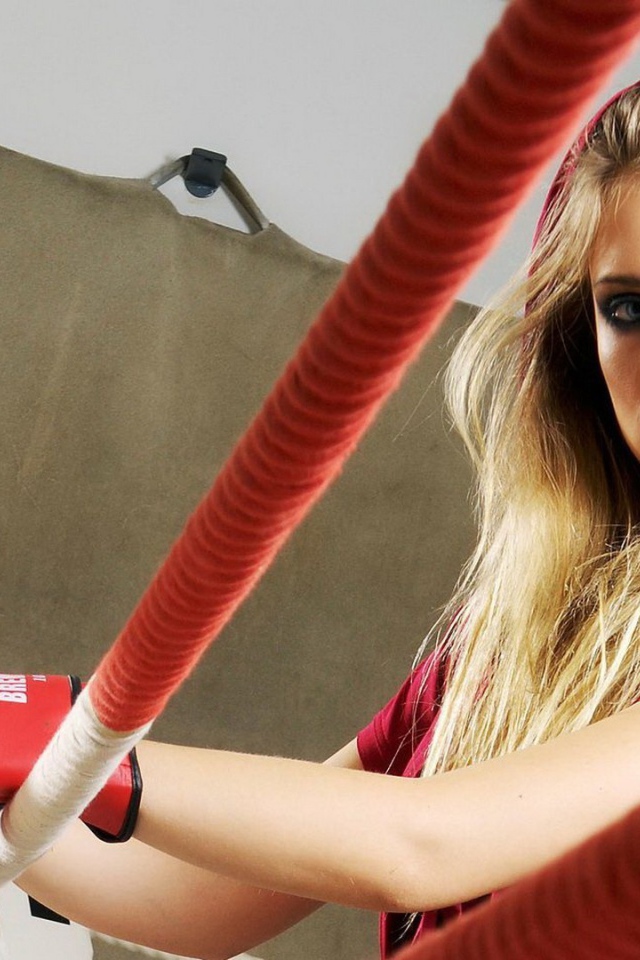 Блондинка в перчатках на боксерском ринге