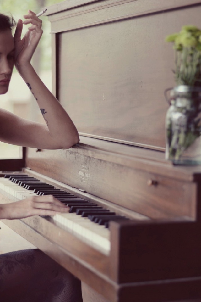 Девушка с тату играет на пианино