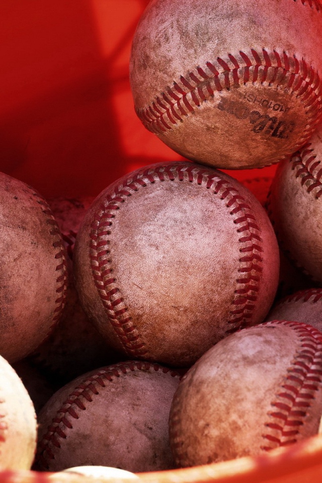 Красное ведро с мячами для бейсбола