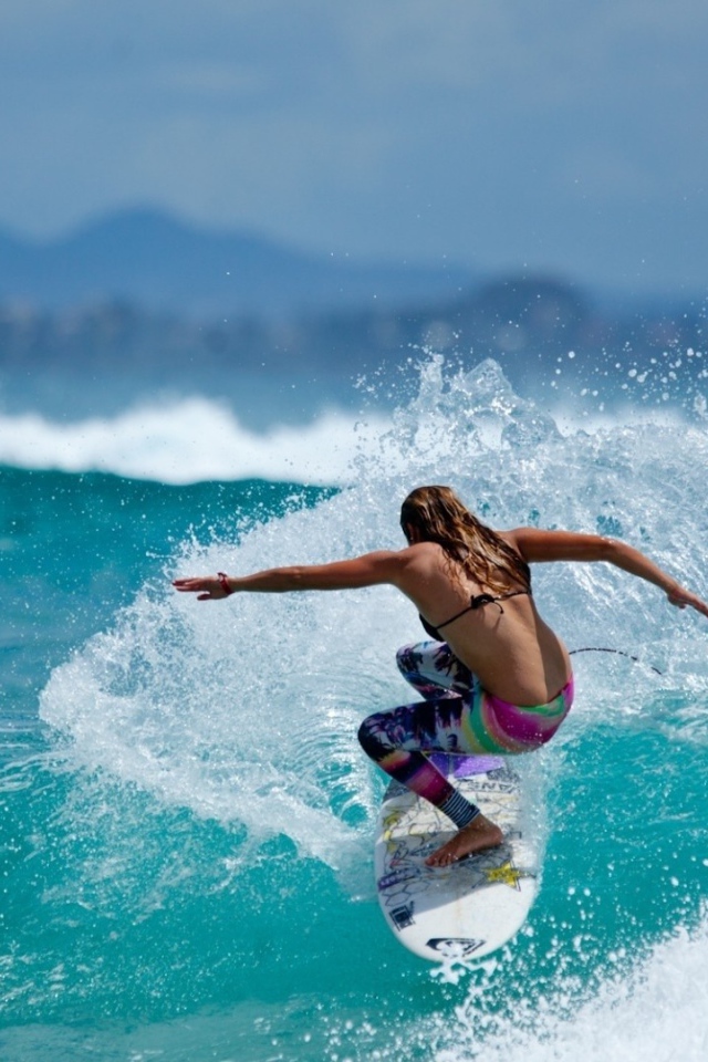 Девушка серфер оседлала голубую волну