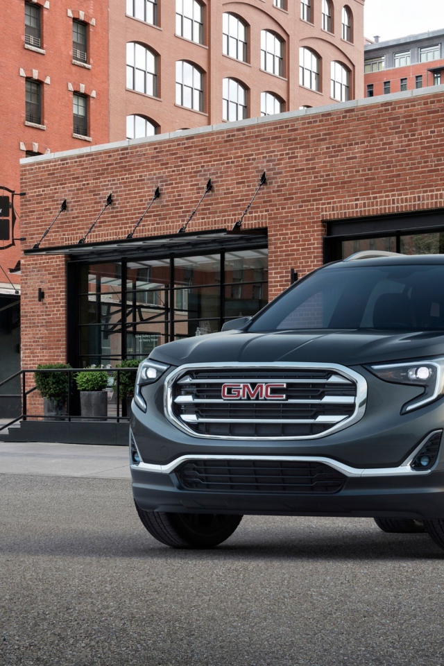 Серый внедорожник GMC Terrain на фоне здания